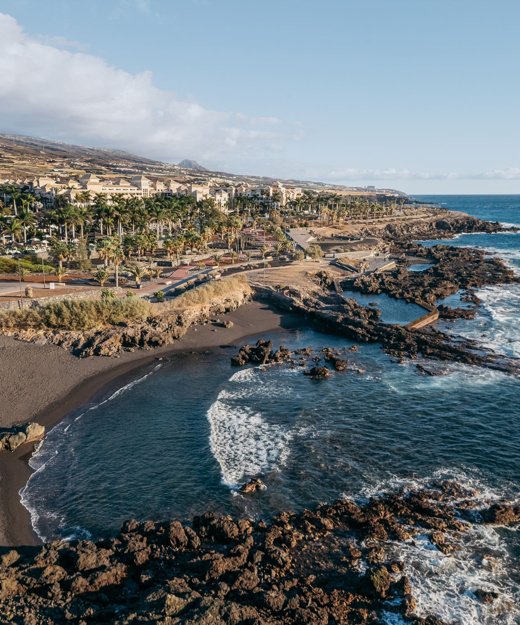 a beach with rocks and buildings