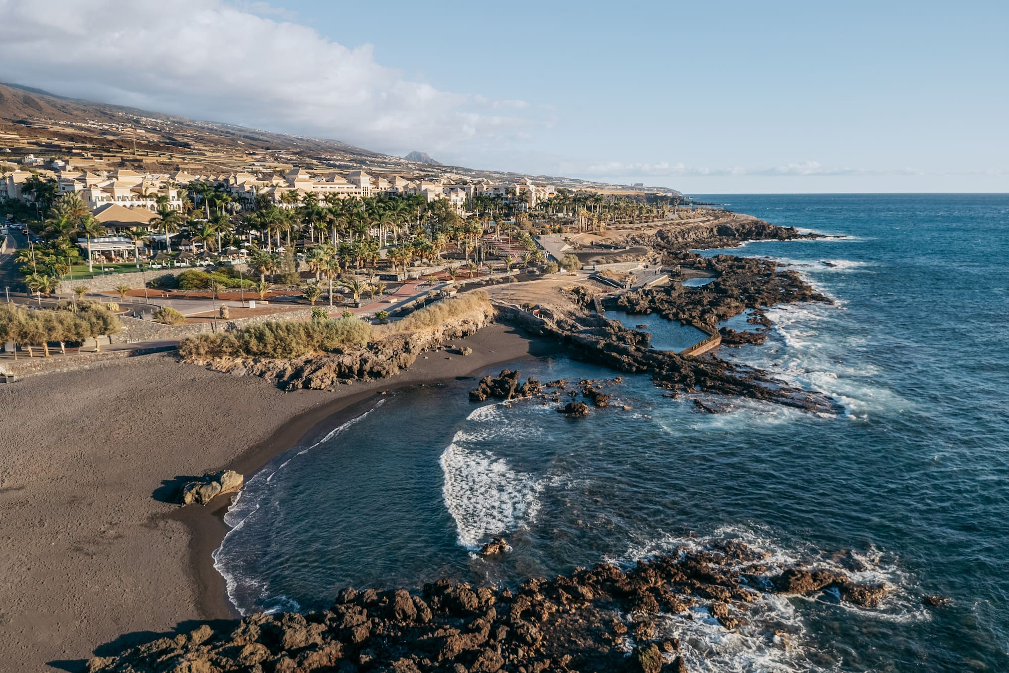 a beach with rocks and buildings