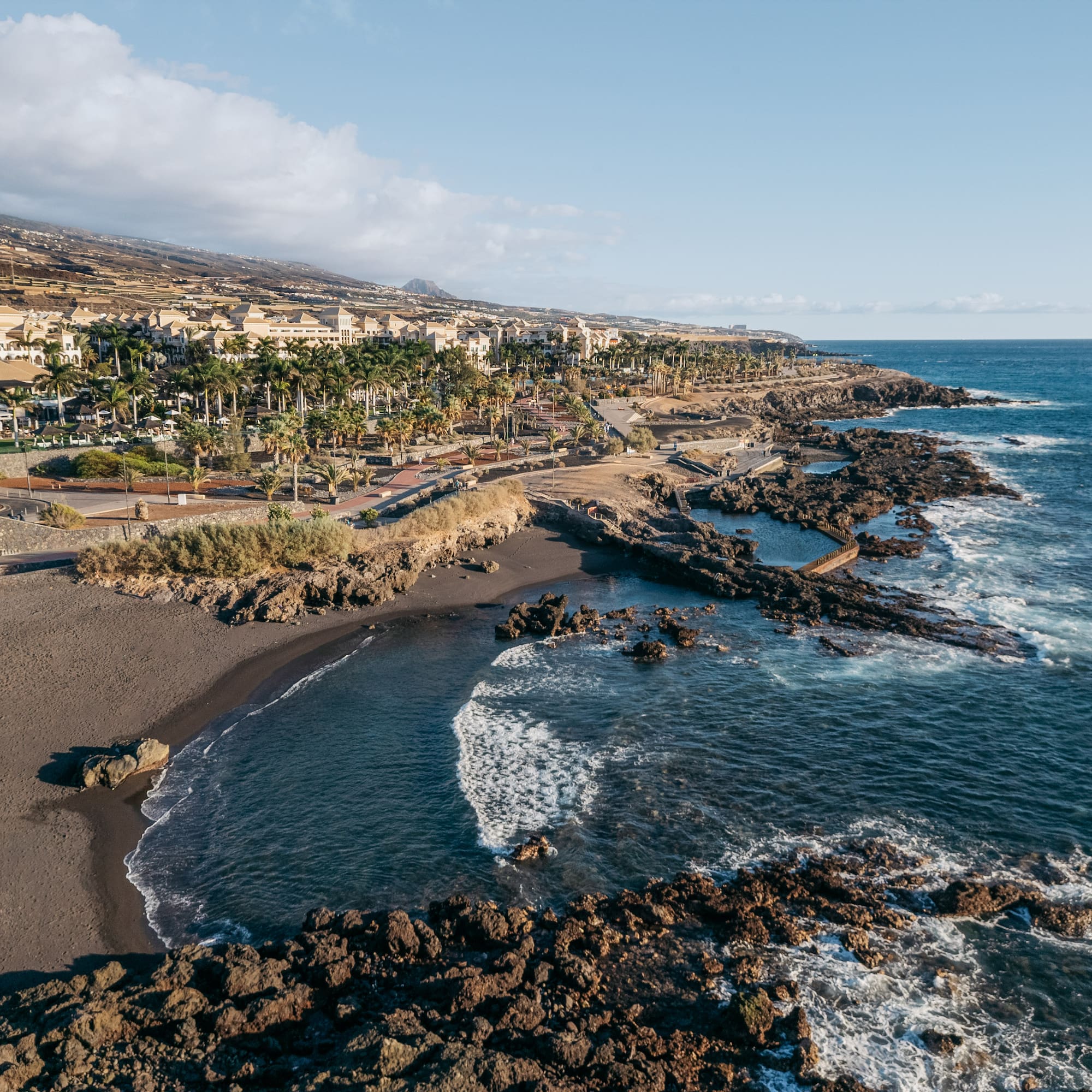 a beach with rocks and buildings