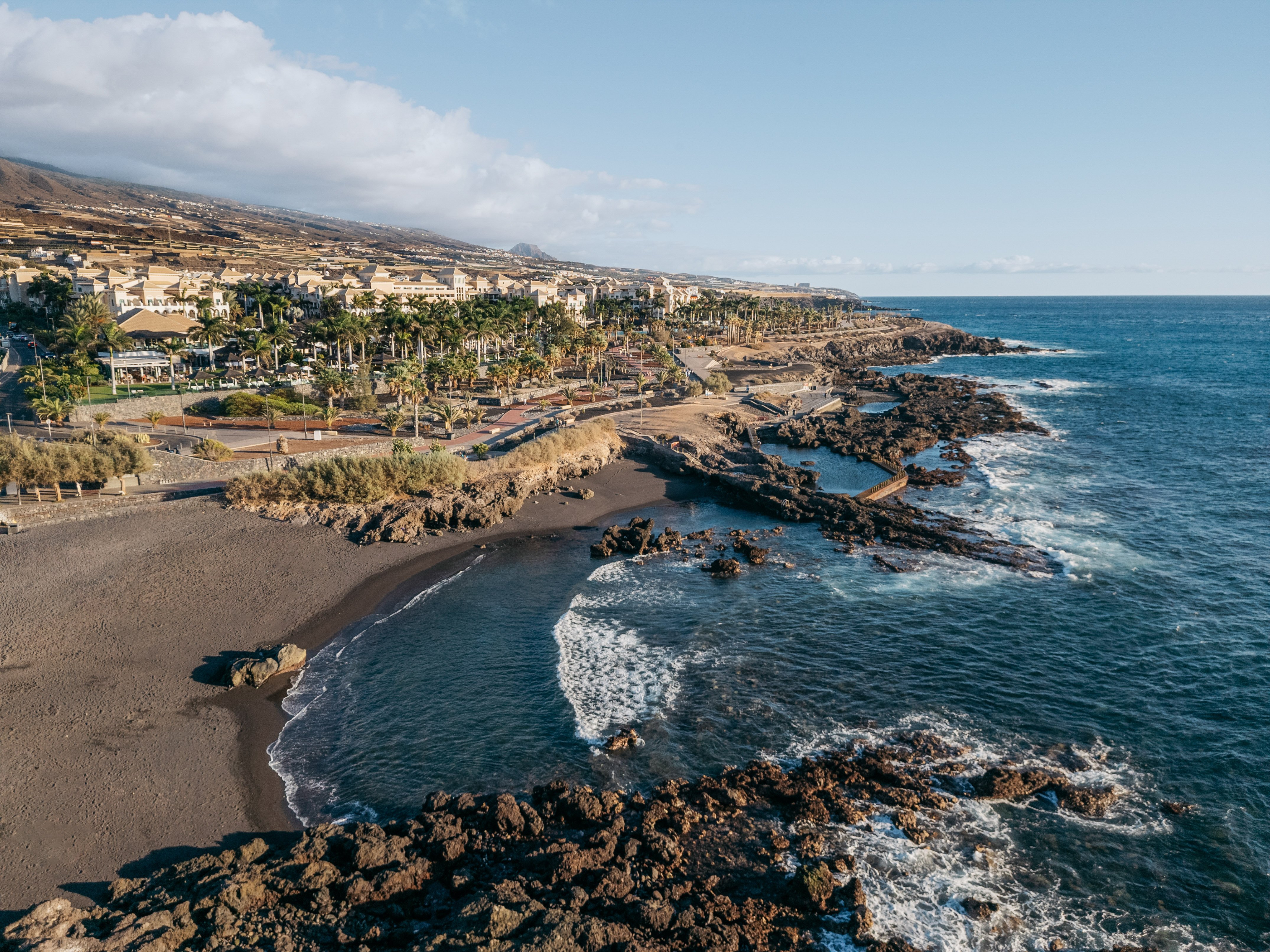 a beach with rocks and buildings