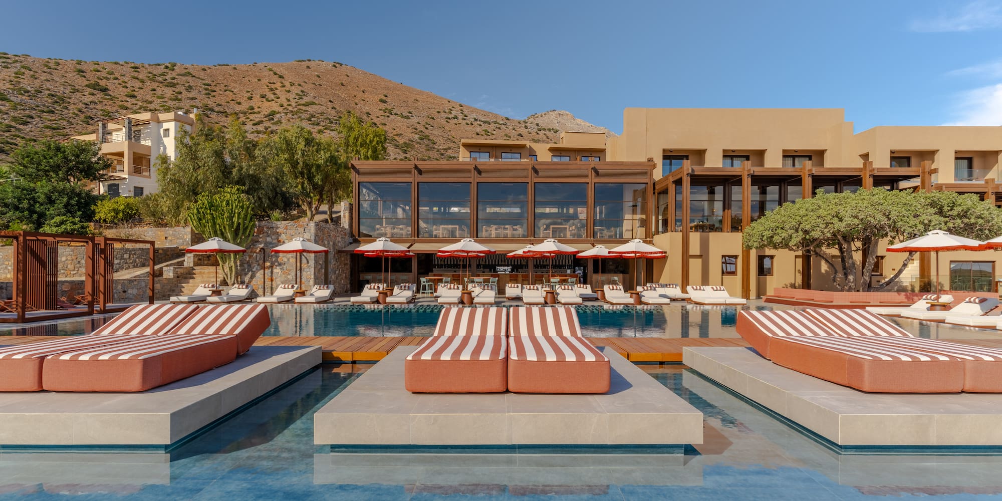 a pool with lounge chairs and a building in the background