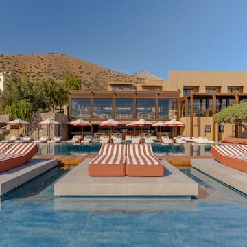 a pool with lounge chairs and a building in the background