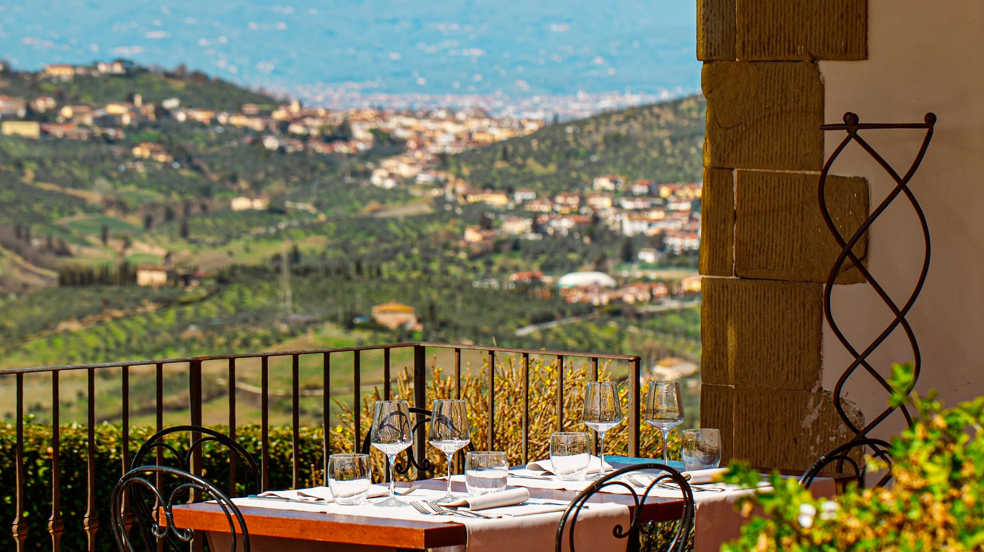 a table and chairs outside with a view of a valley in the background