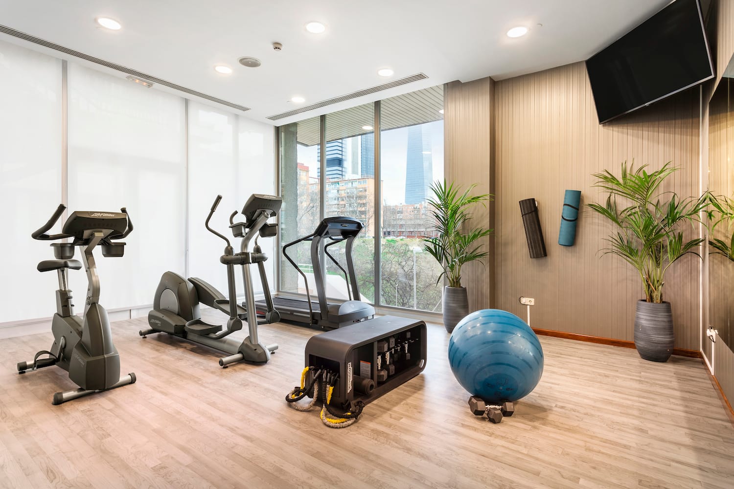 a room with exercise equipment and a large window