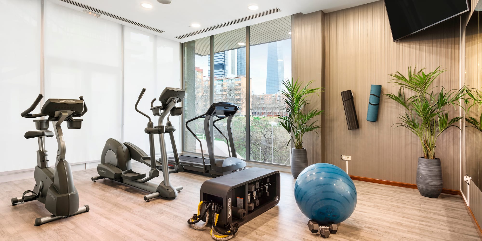 a room with exercise equipment and a large window