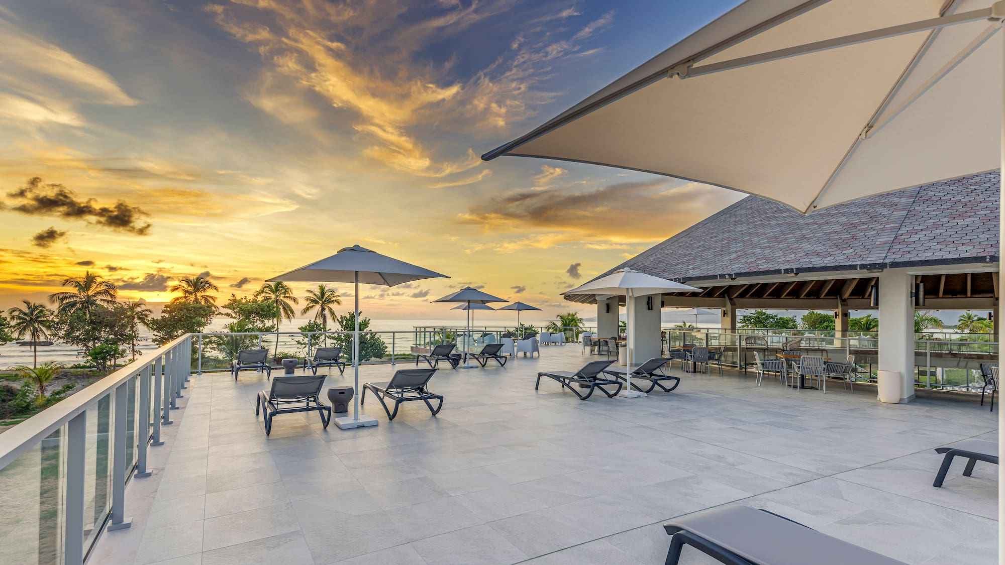 a deck with chairs and umbrellas on a sunny day