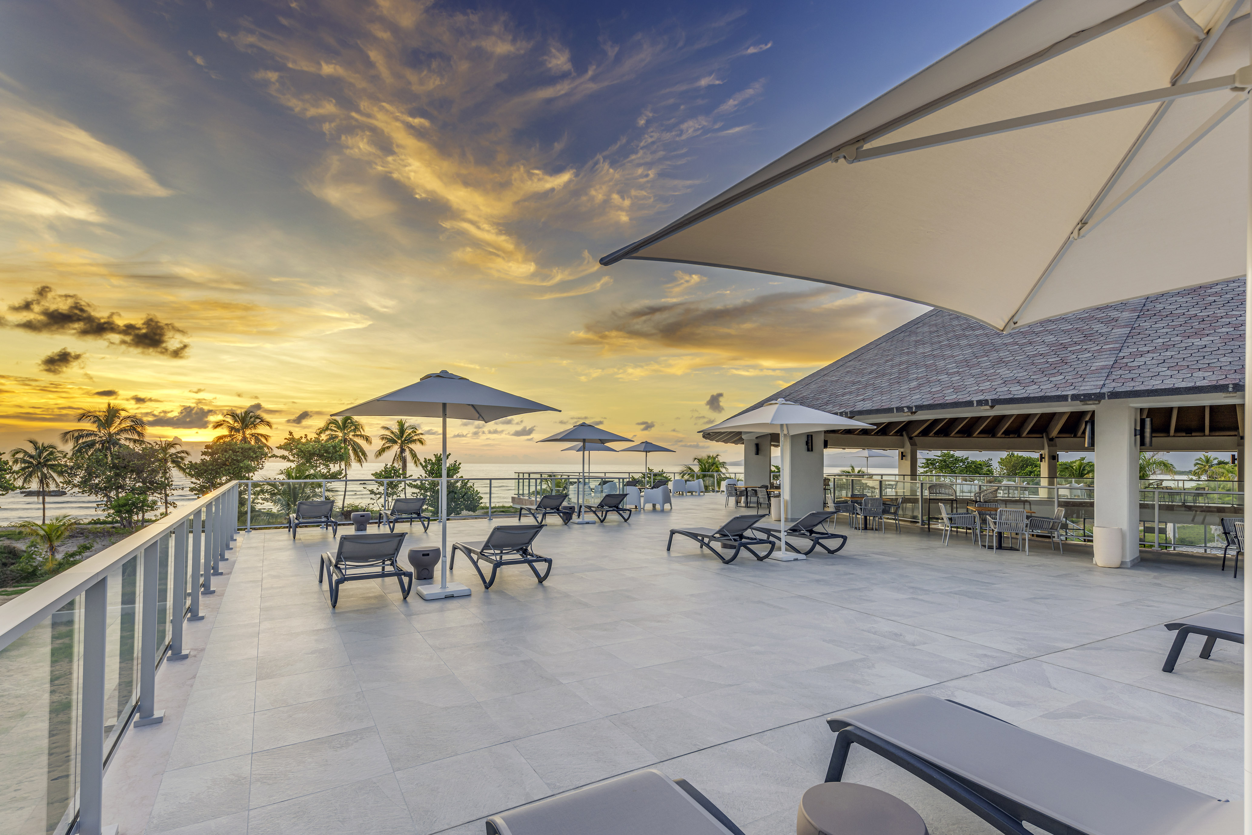 a deck with chairs and umbrellas on a sunny day