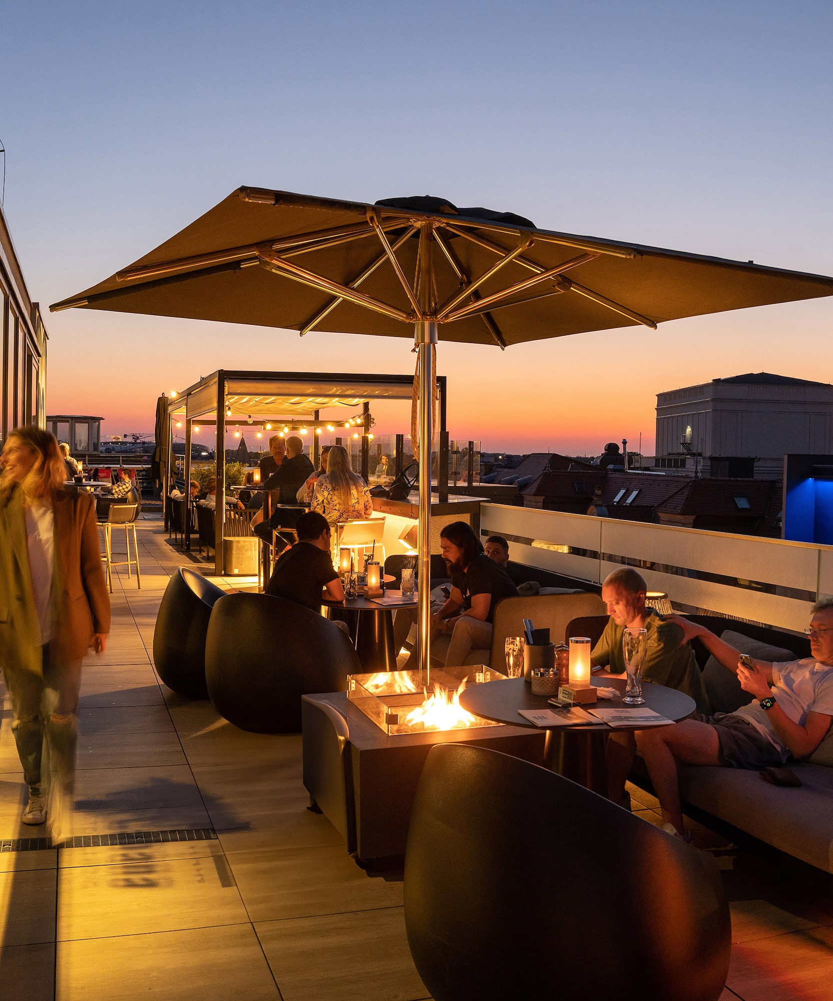 a group of people sitting at tables on a rooftop