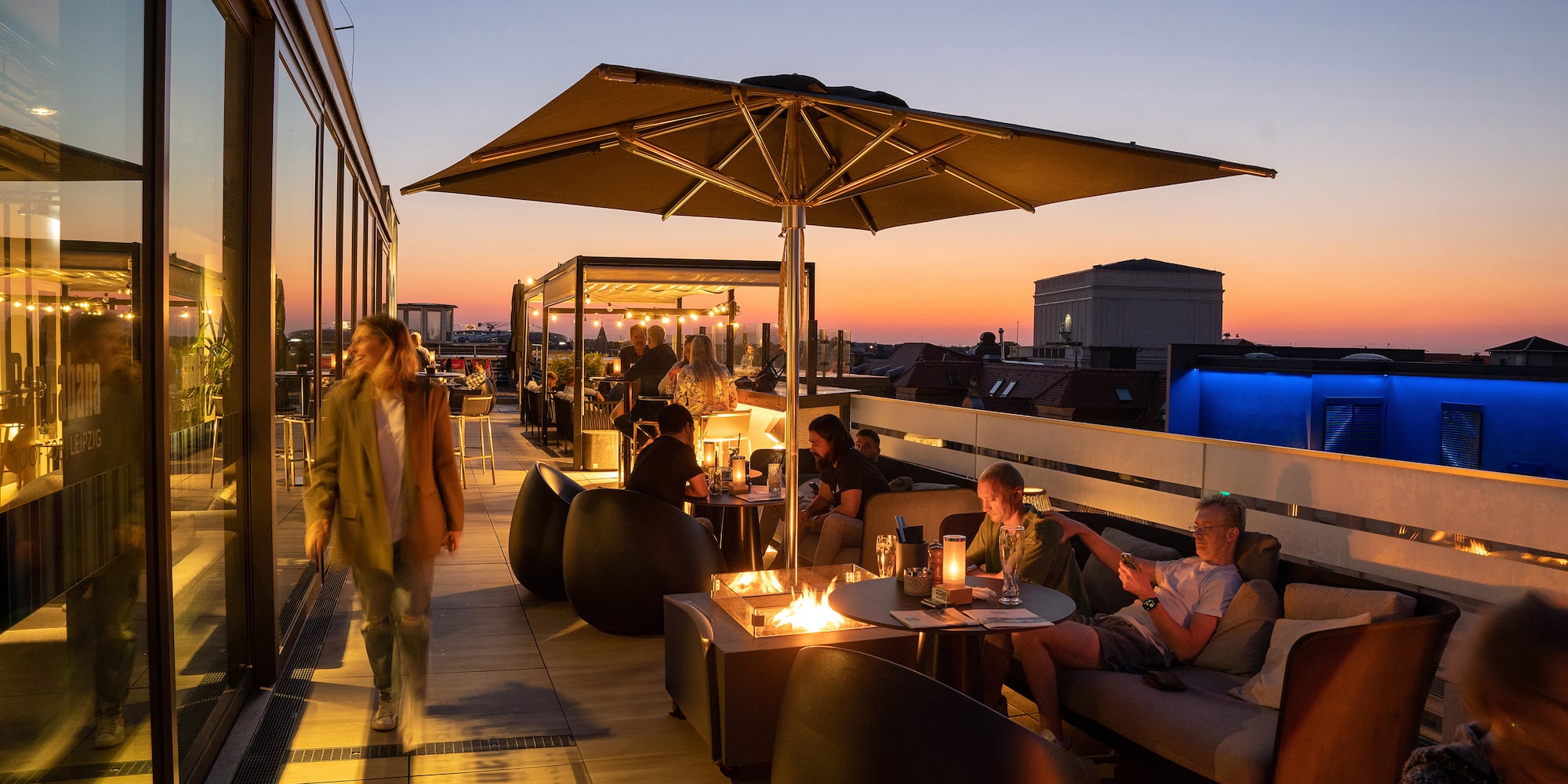 a group of people sitting at tables on a rooftop