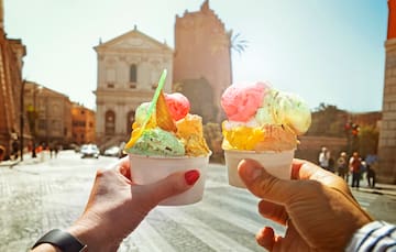 two hands holding two cups of ice cream