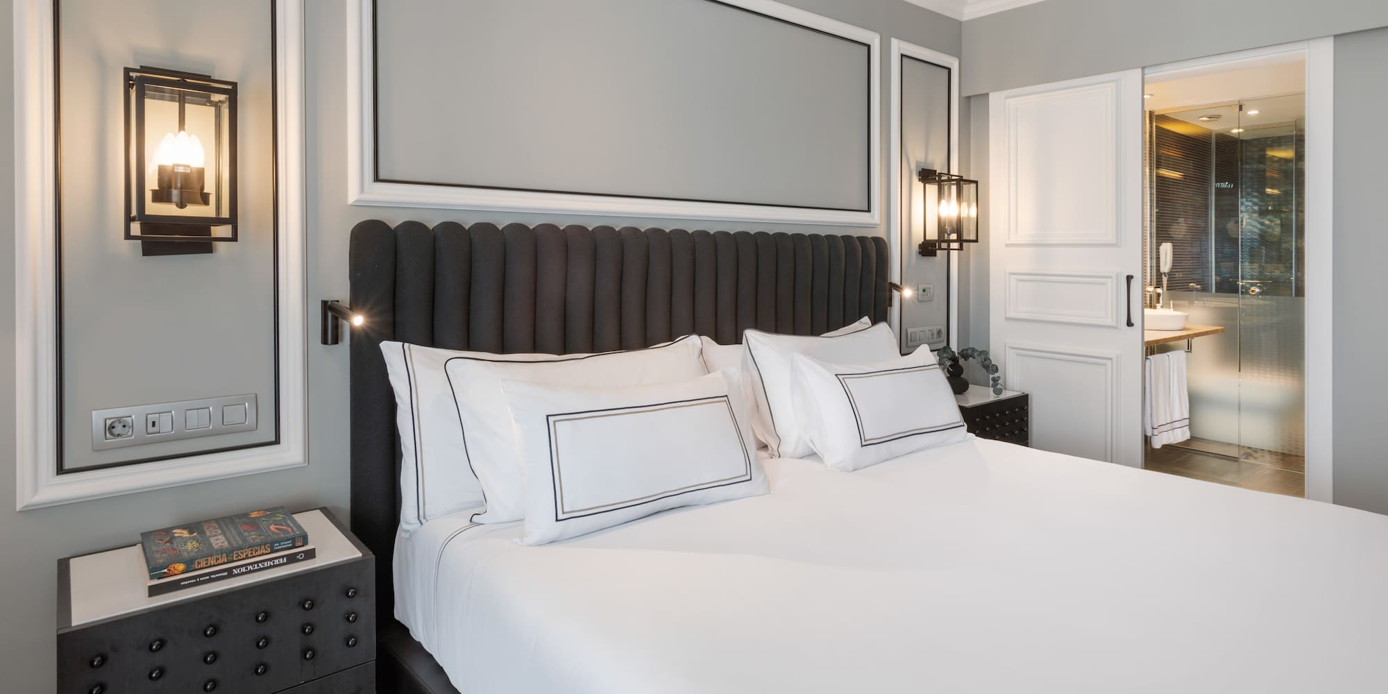 a bed with white sheets and pillows in a room