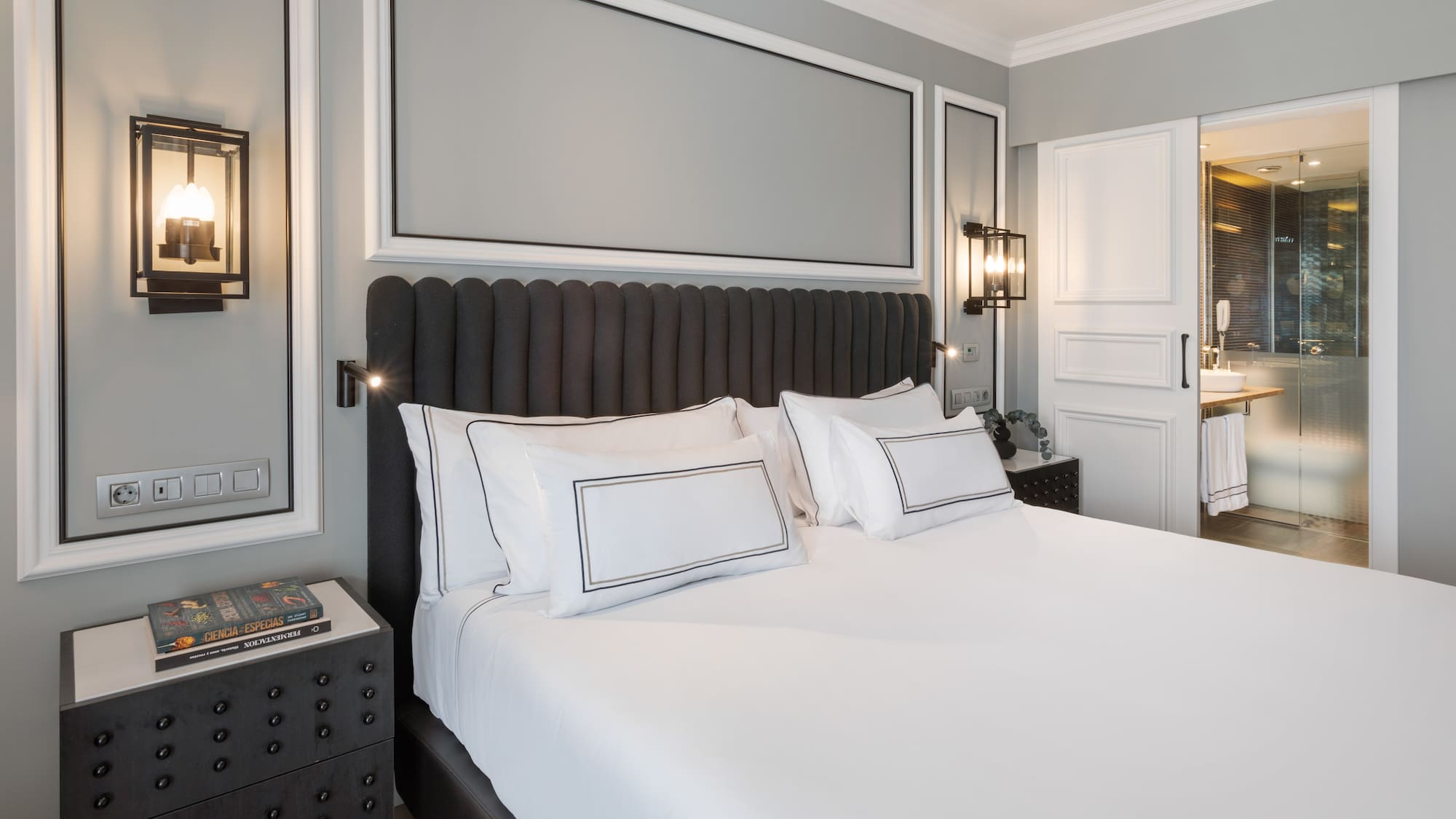 a bed with white sheets and pillows in a room