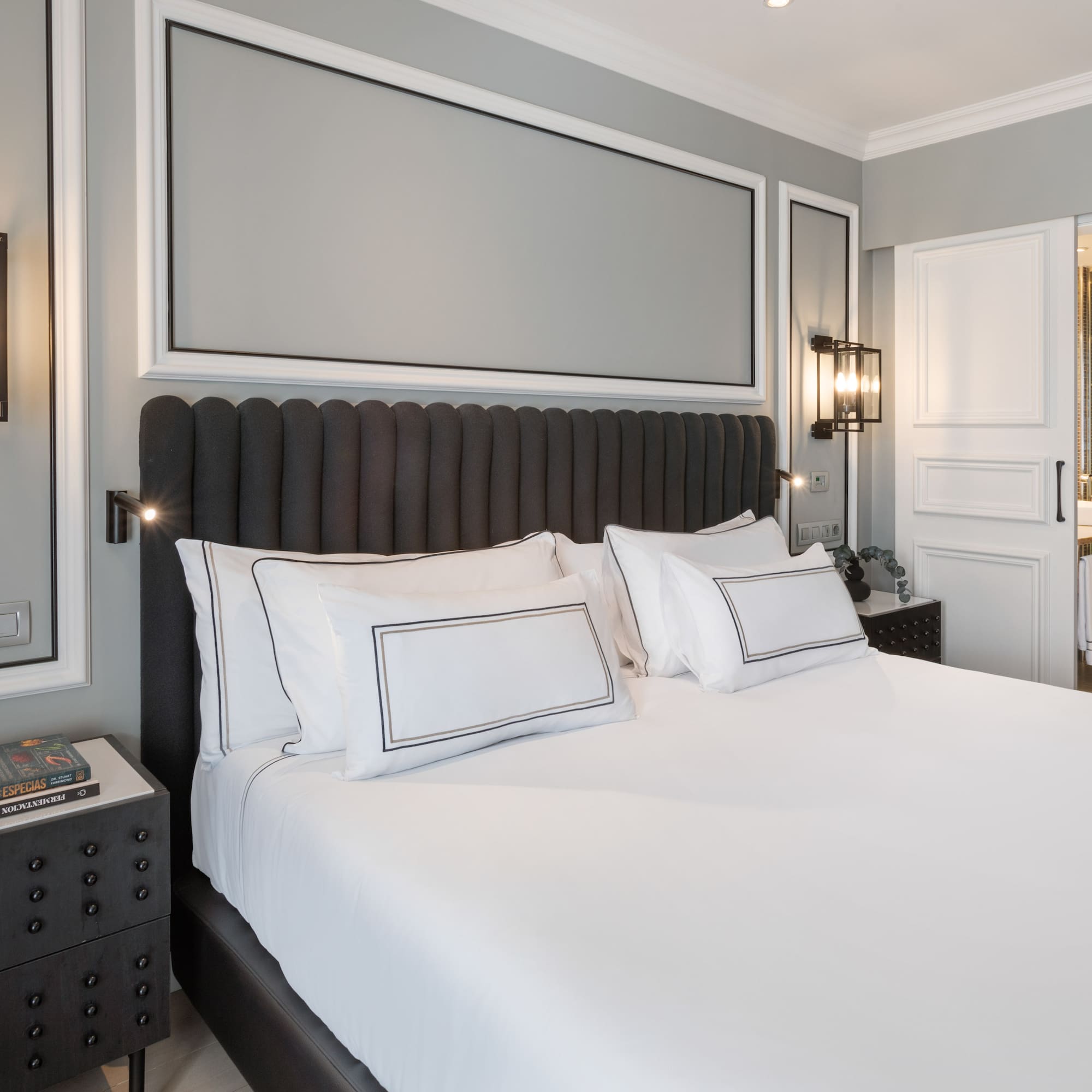 a bed with white sheets and pillows in a room