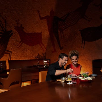 a man and woman sitting at a table eating food