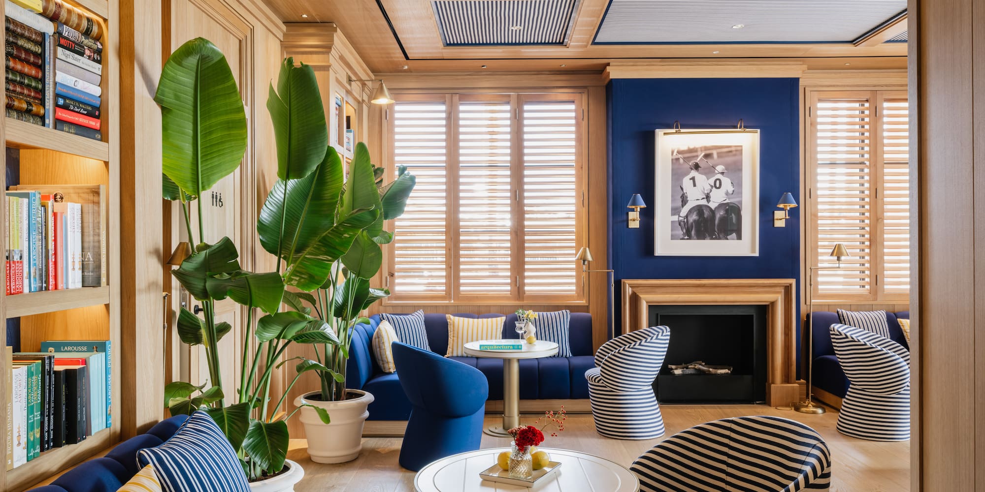 a room with blue walls and blue couches and a table with a fireplace