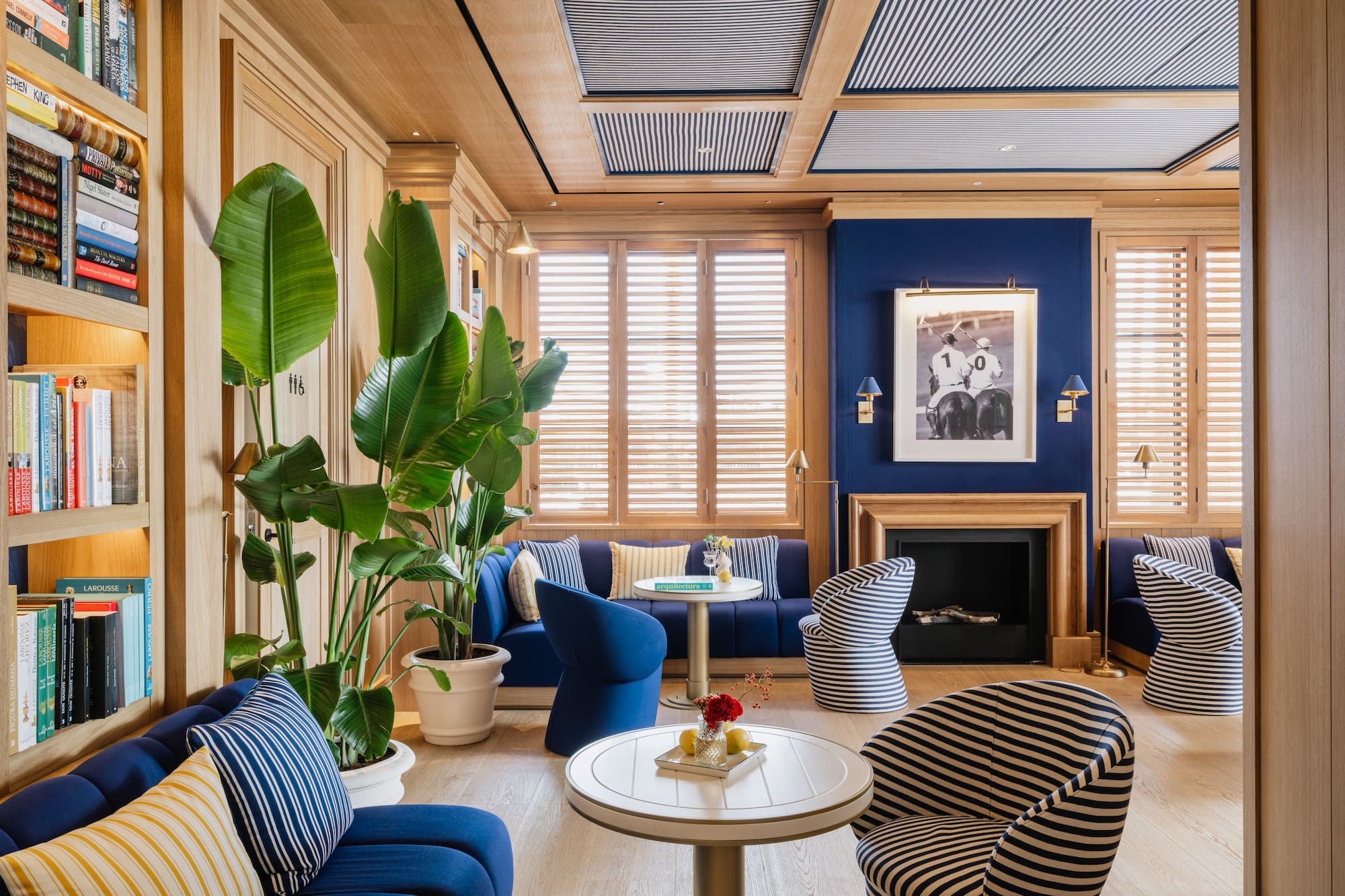 a room with blue walls and blue couches and a table with a fireplace