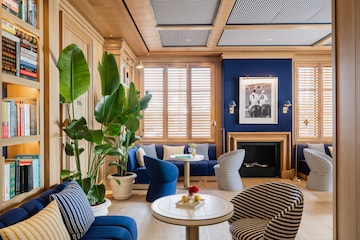 a room with blue walls and blue couches and a table with a fireplace