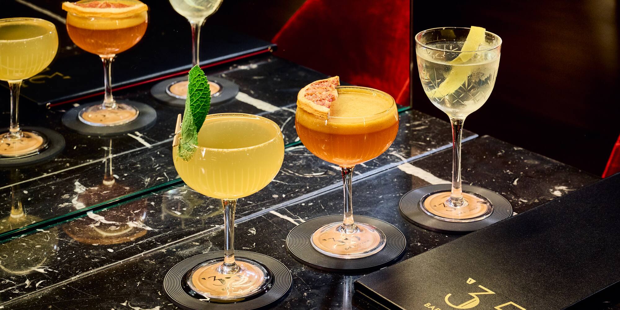 a group of glasses of different colored drinks on a table
