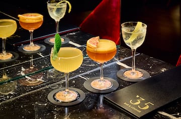 a group of glasses of different colored drinks on a table