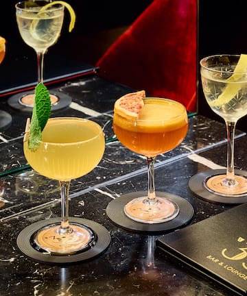 a group of glasses of different colored drinks on a table