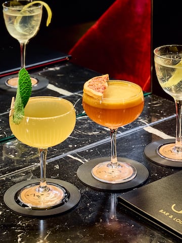 a group of glasses of different colored drinks on a table