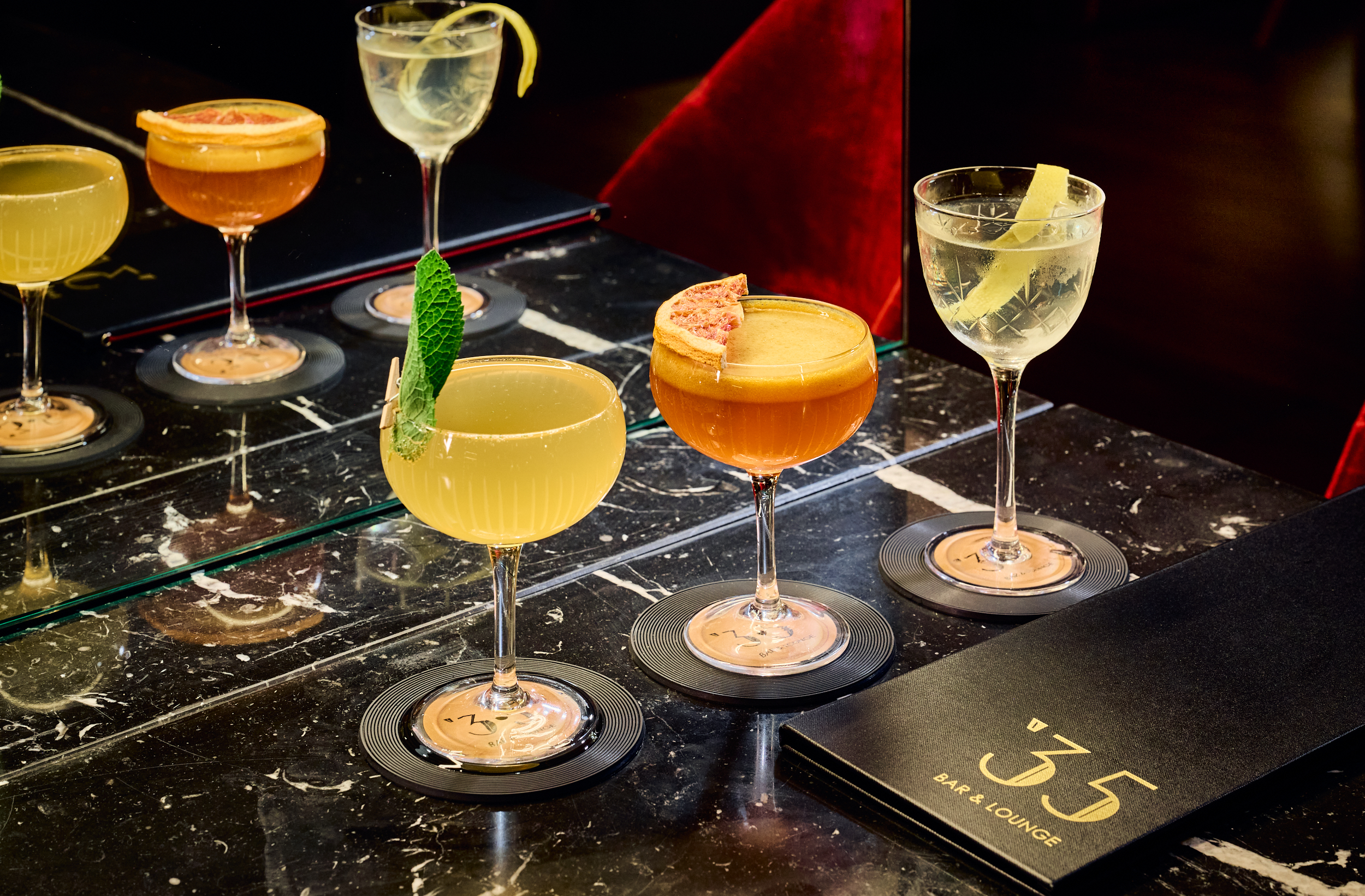 Cocktails with grapefruit, mint, lemon on dark marble at 35 Bar & Lounge.