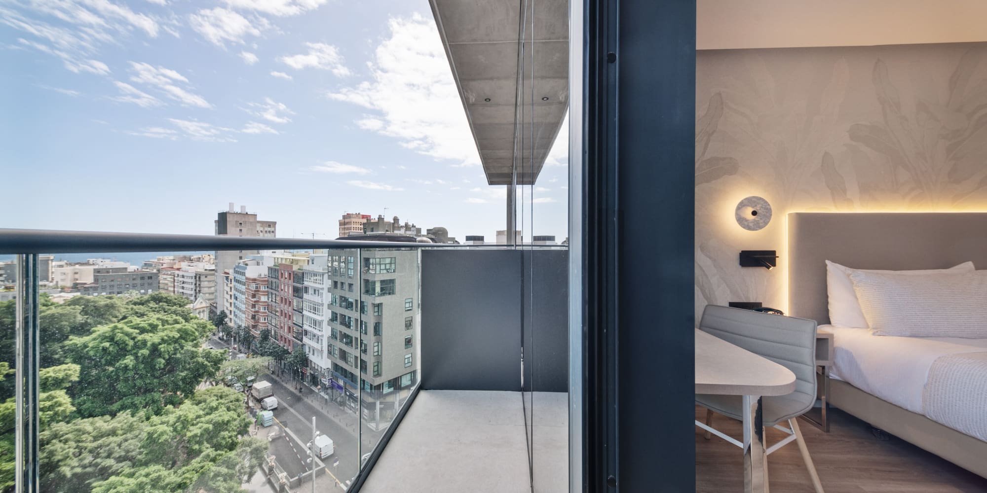 a balcony with a table and chairs and a view of a city