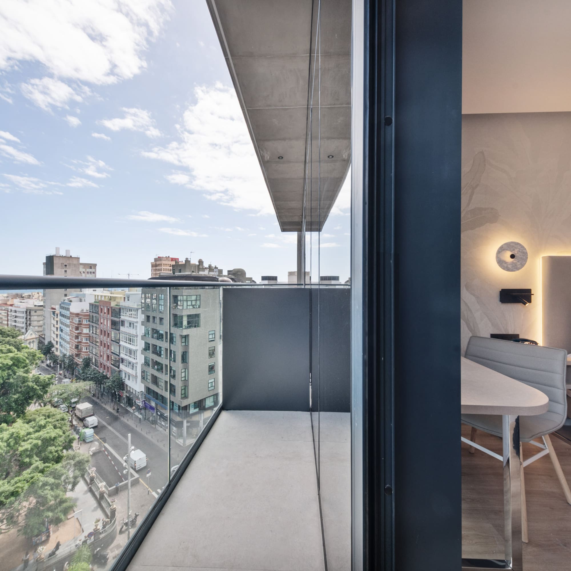 a balcony with a table and chairs and a view of a city