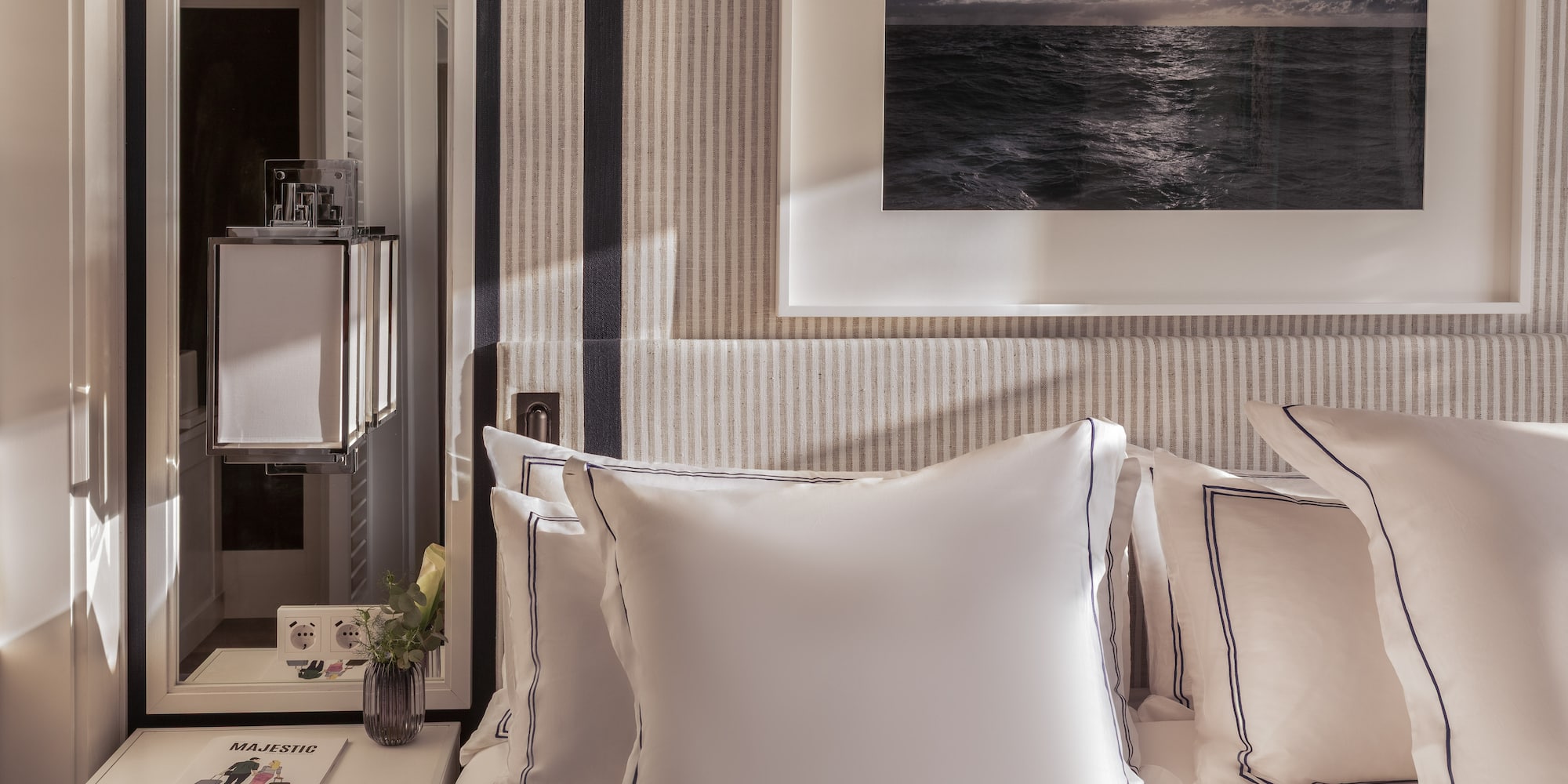 a bed with pillows and a picture on the wall