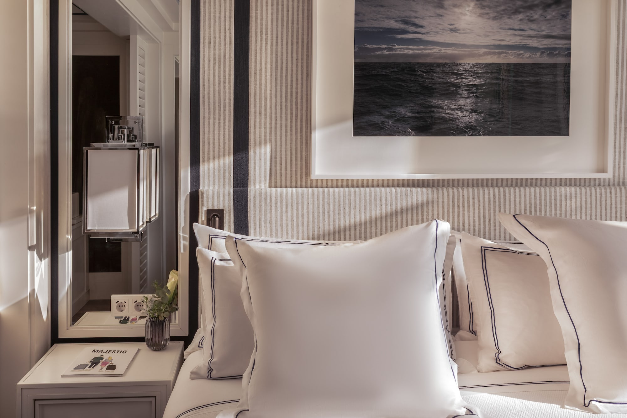 a bed with pillows and a picture on the wall