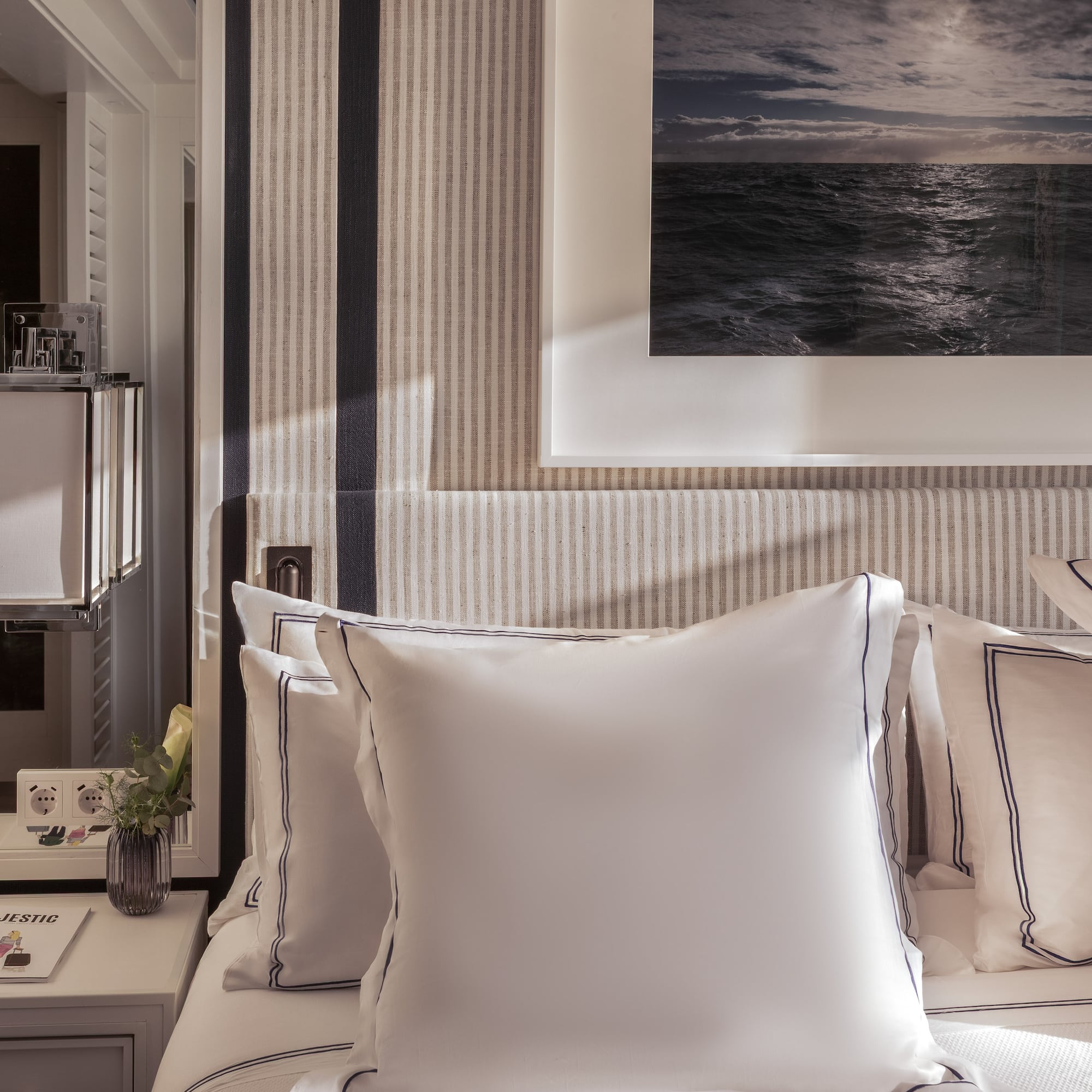 a bed with pillows and a picture on the wall