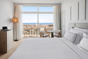 a bedroom with a large window overlooking the ocean