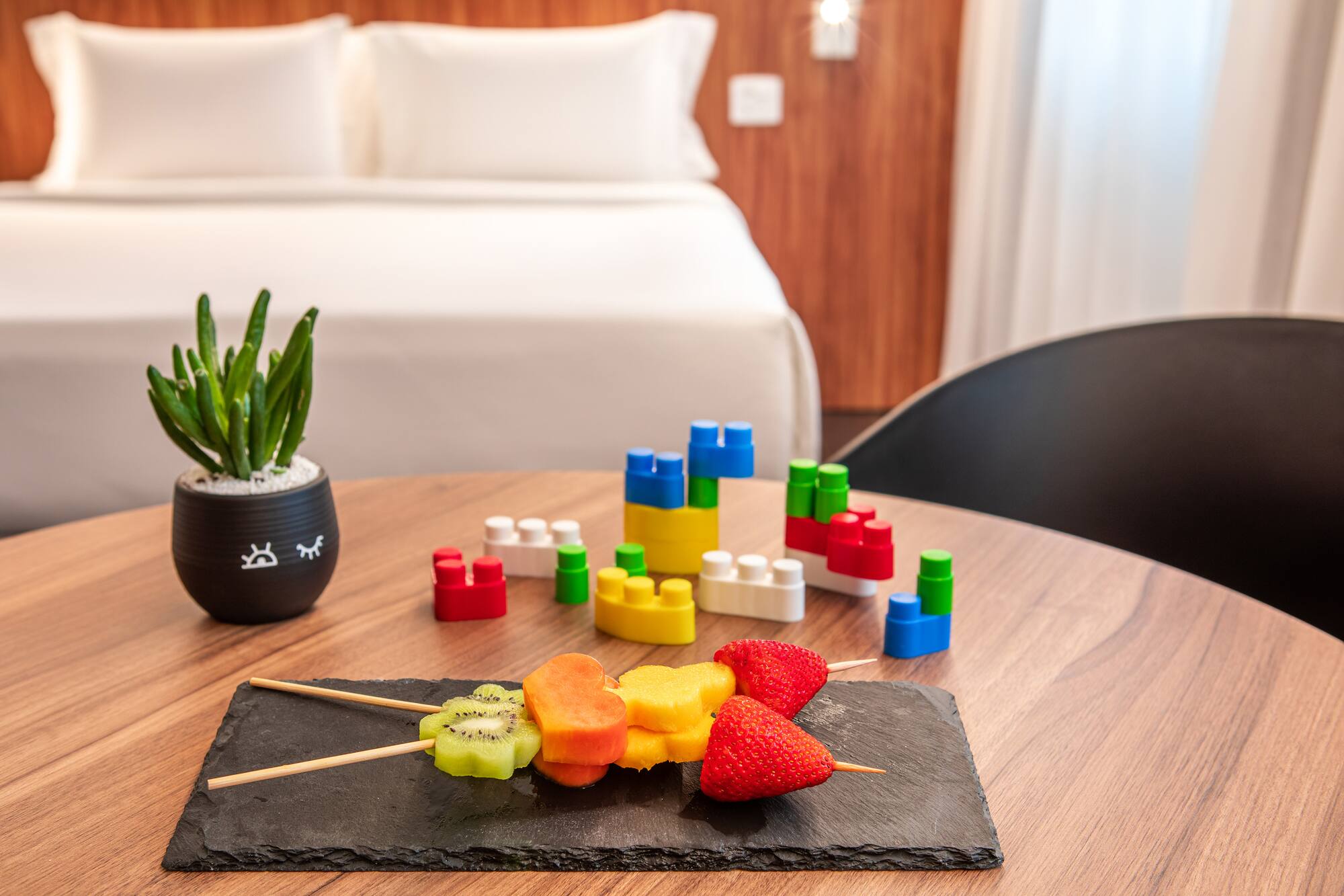 Family hotel room with healthy fruit snacks and kids' building block toys.