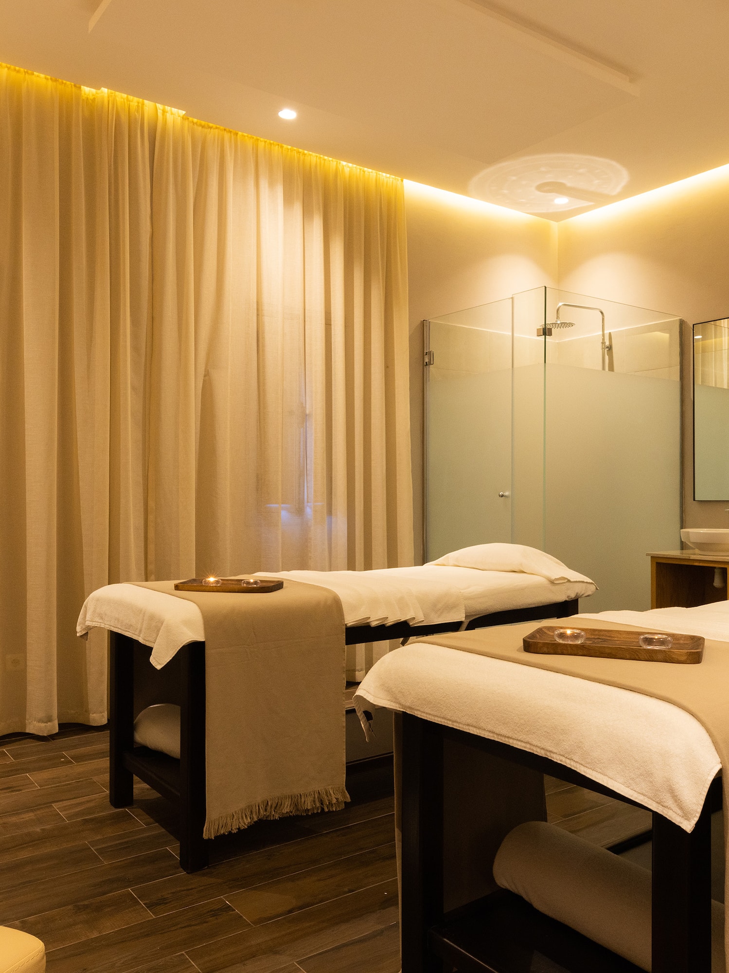 a massage room with beds and a shower