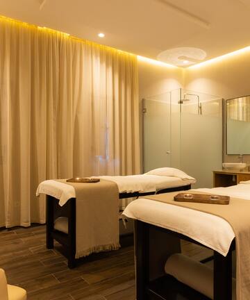 a massage room with beds and a shower