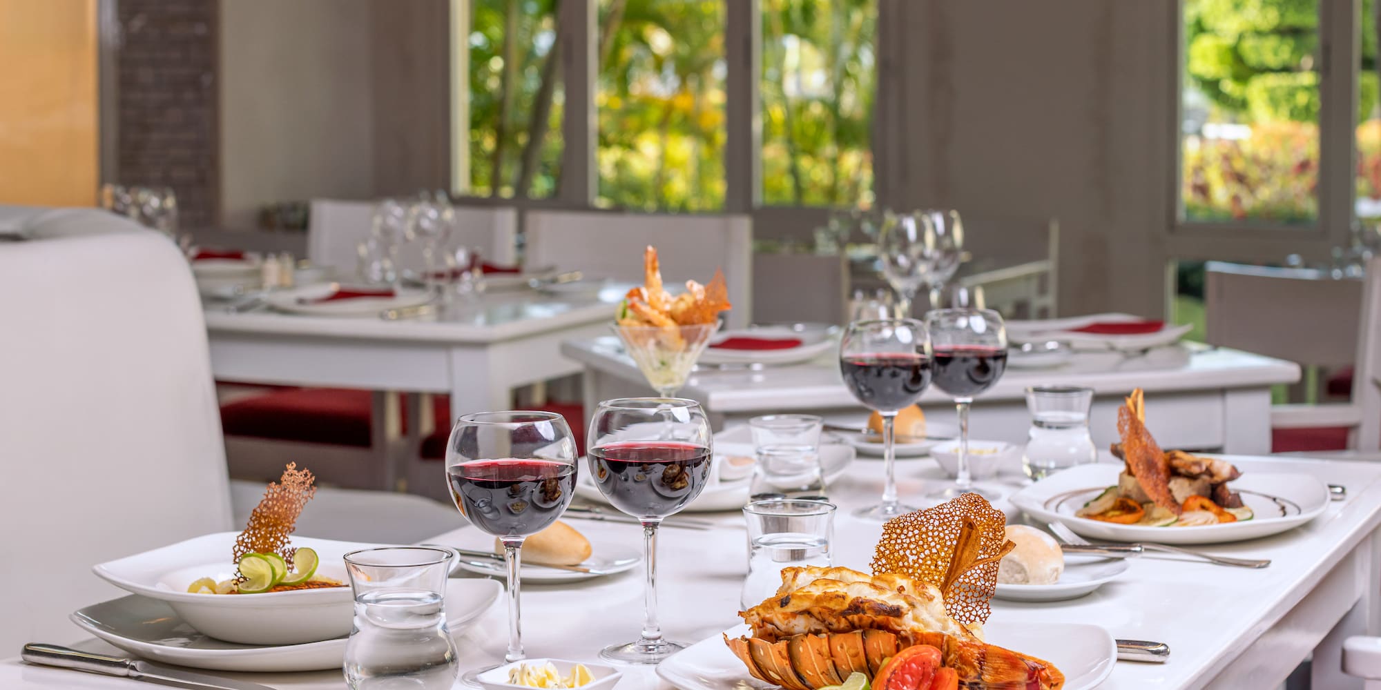 a table with plates of food and glasses of wine