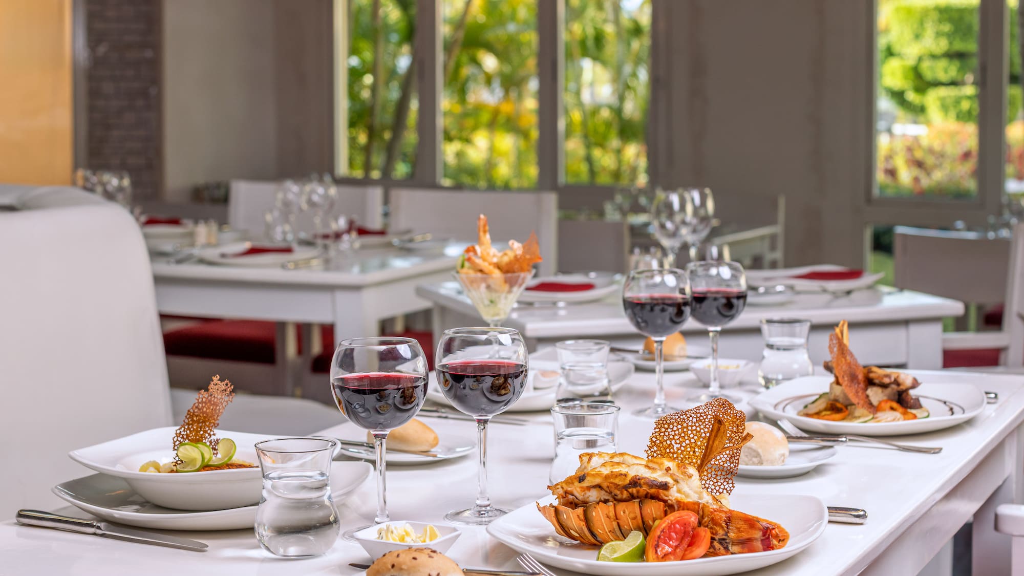 a table with plates of food and glasses of wine