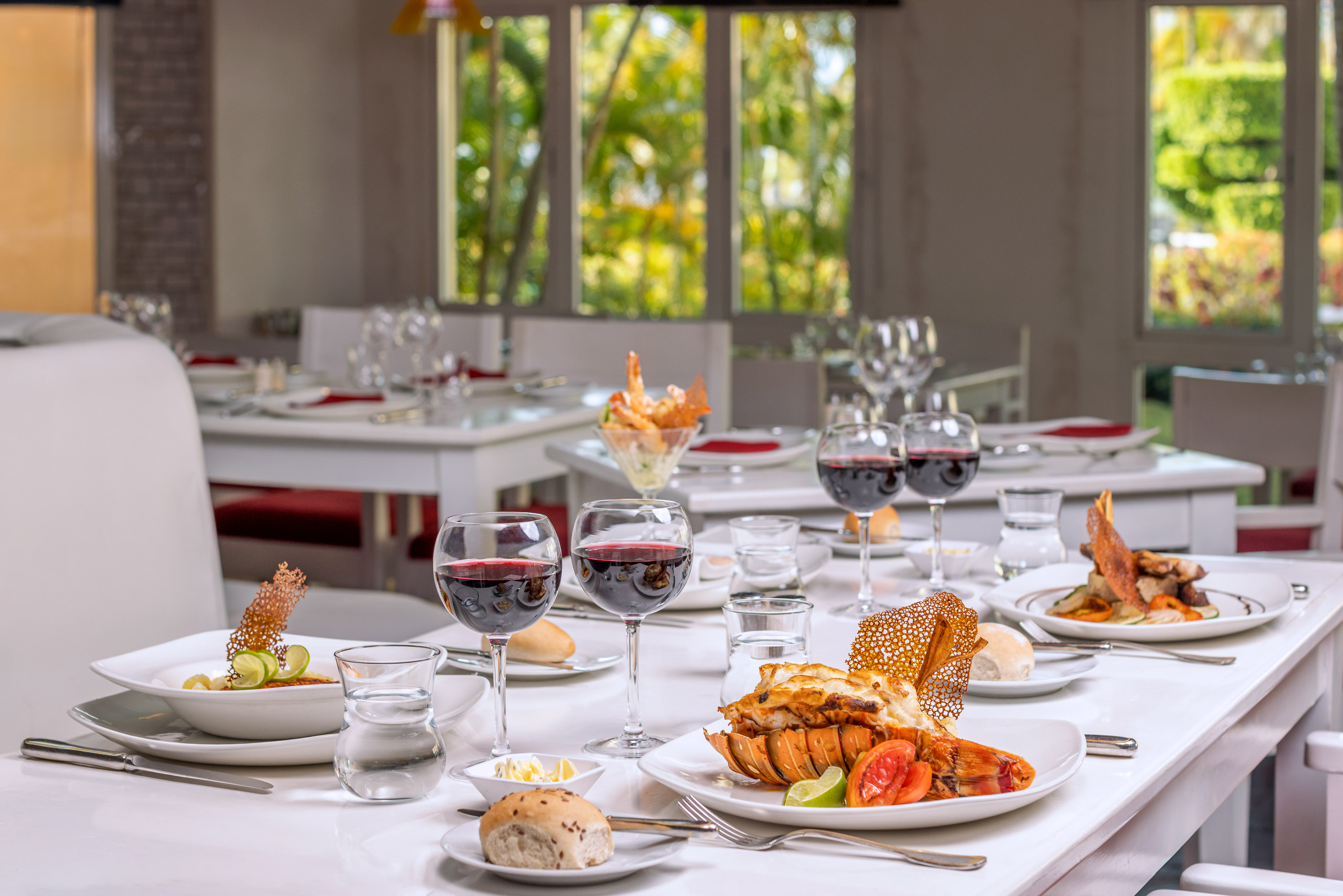 a table with plates of food and glasses of wine