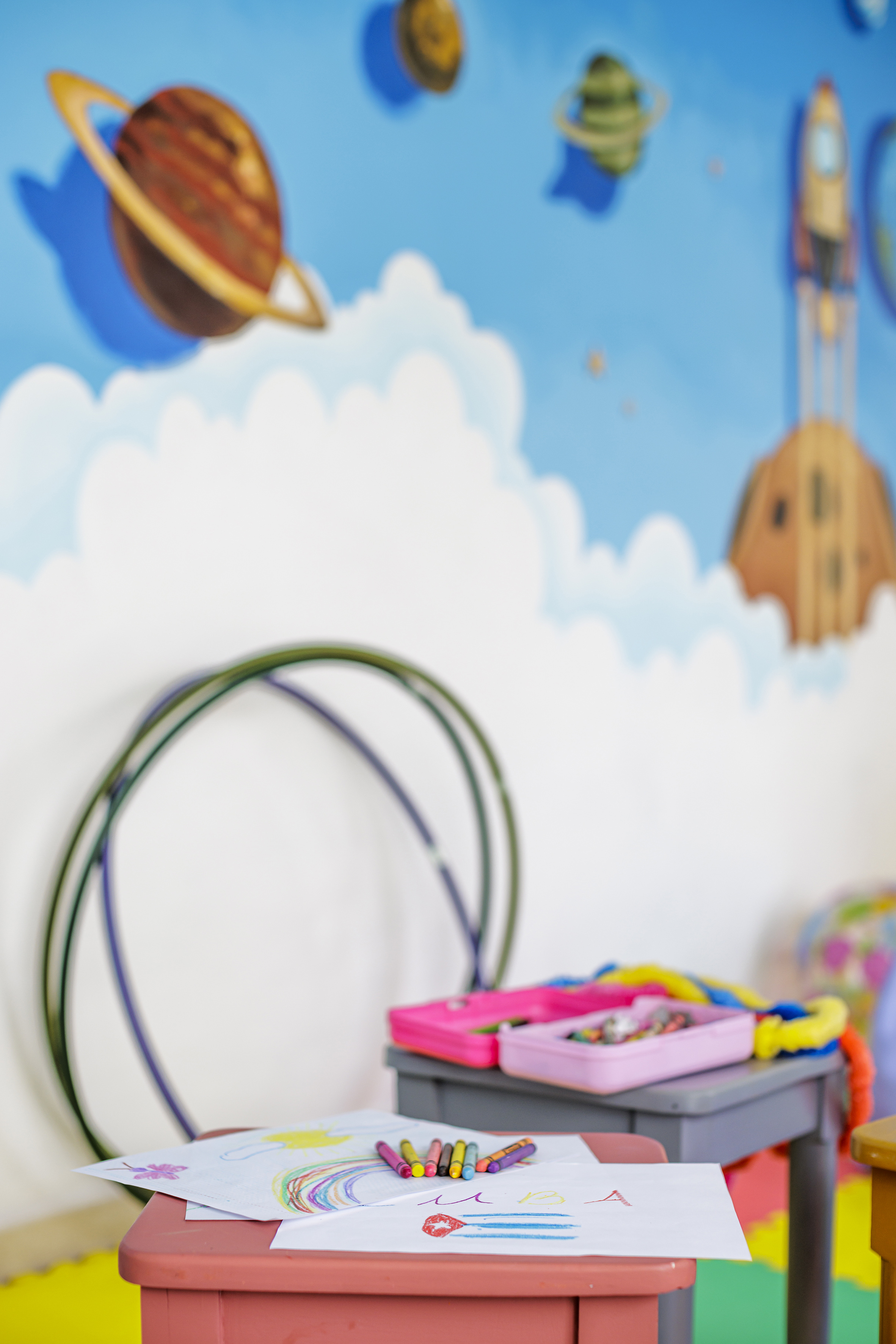 a room with a wall mural and a toy box