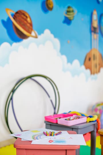 a room with a wall mural and a toy box
