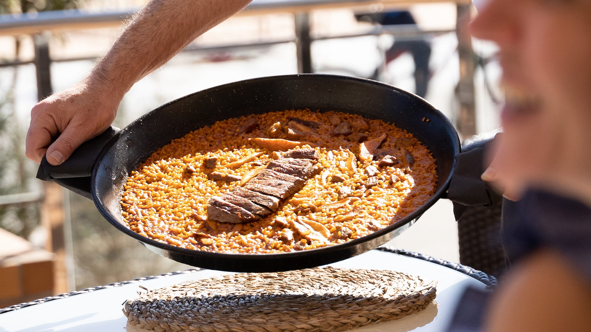 a person holding a pan with food in it