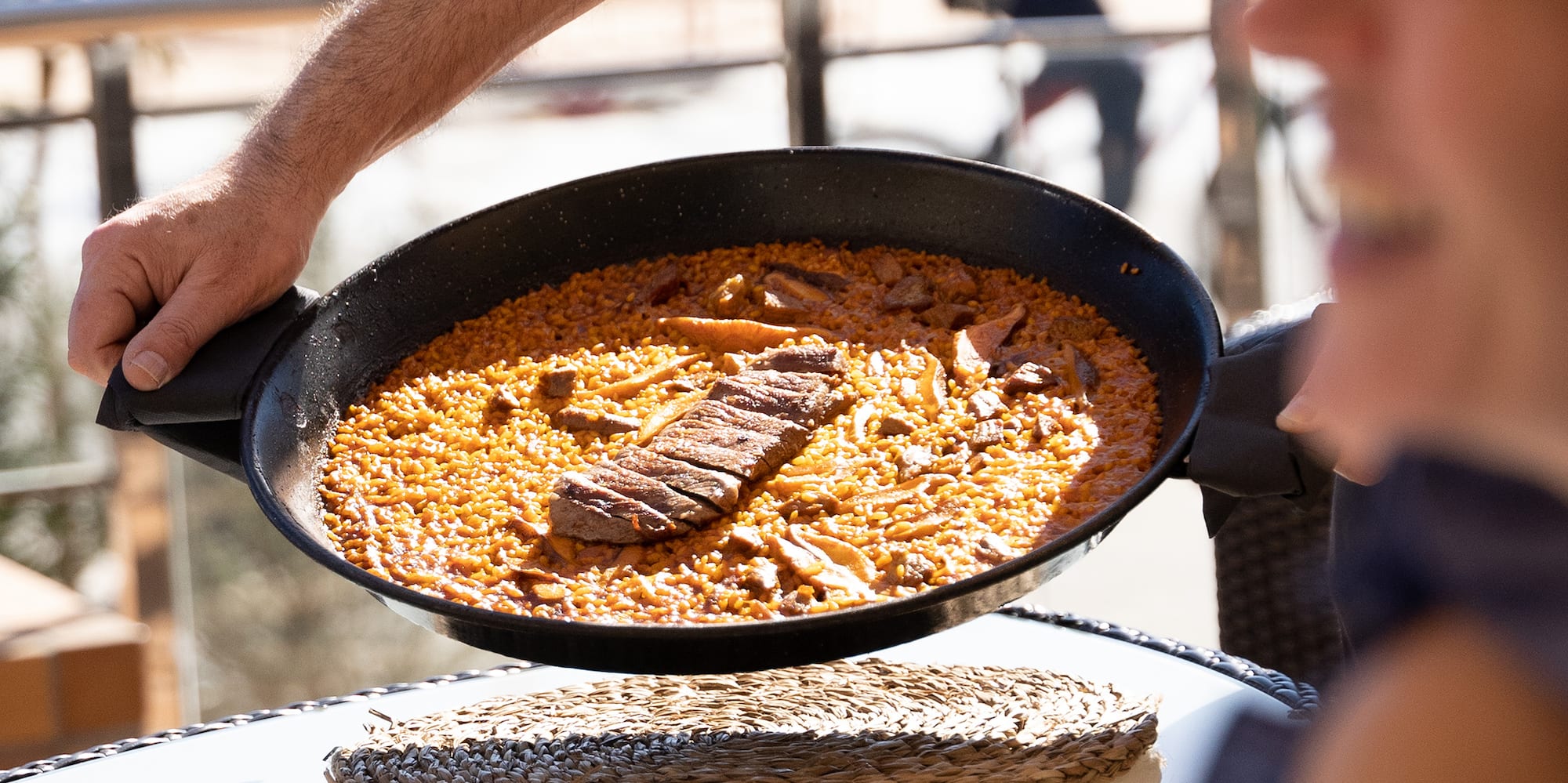 a person holding a pan with food in it