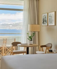 a room with a bed and chairs and a table and chairs