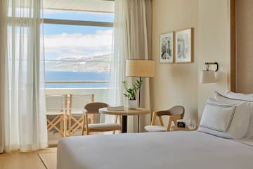 a room with a bed and chairs and a table and chairs