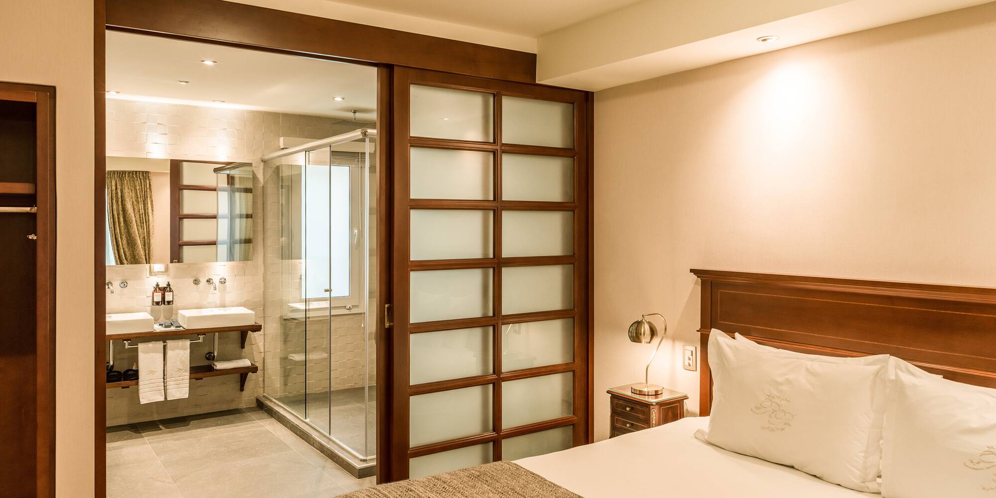 a bedroom with a glass door and a sink