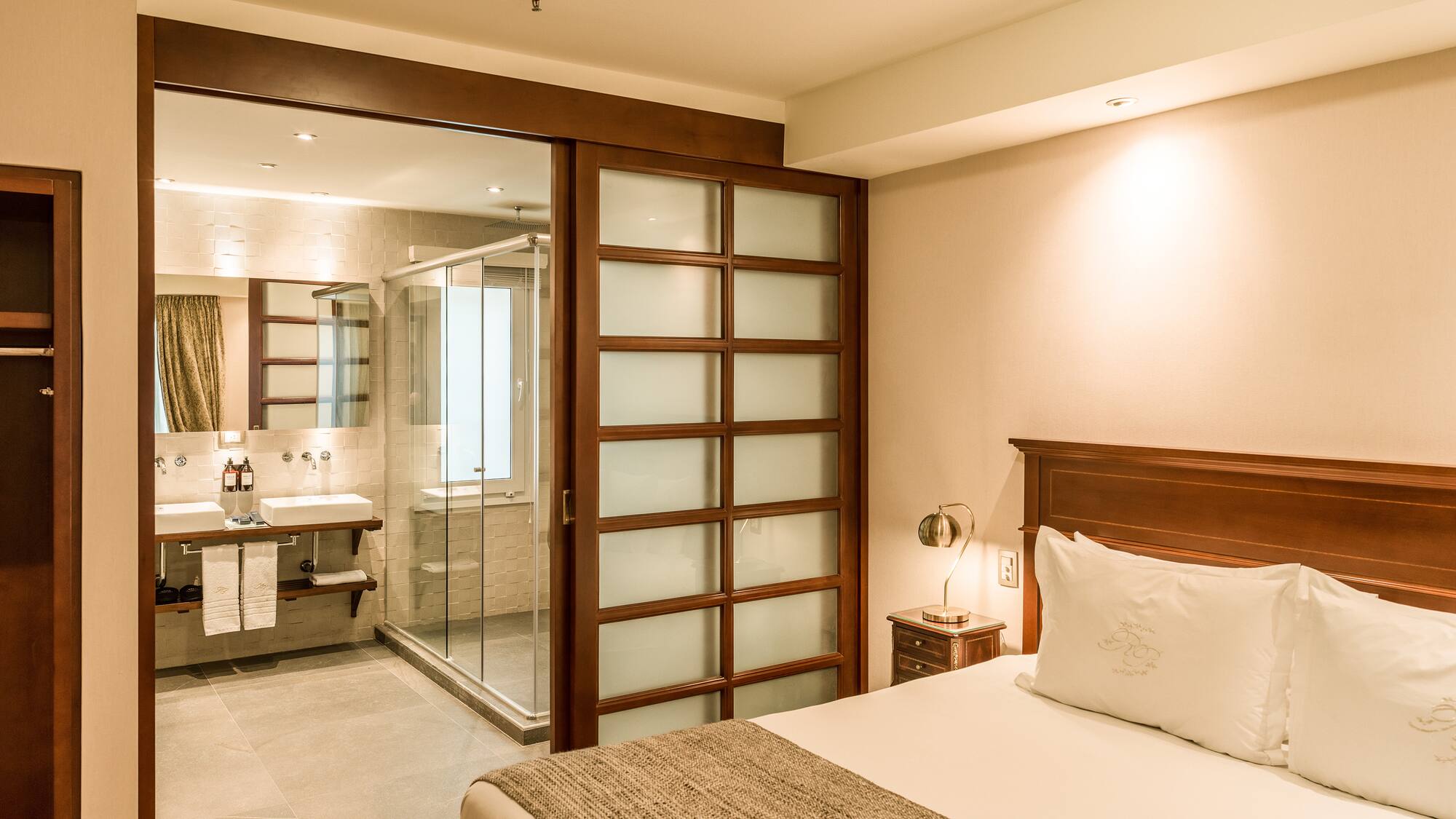 a bedroom with a glass door and a sink