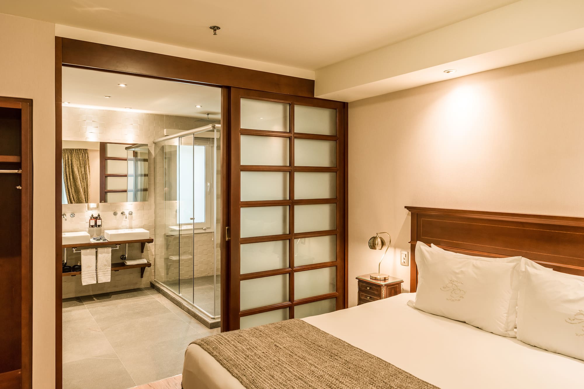 a bedroom with a glass door and a sink