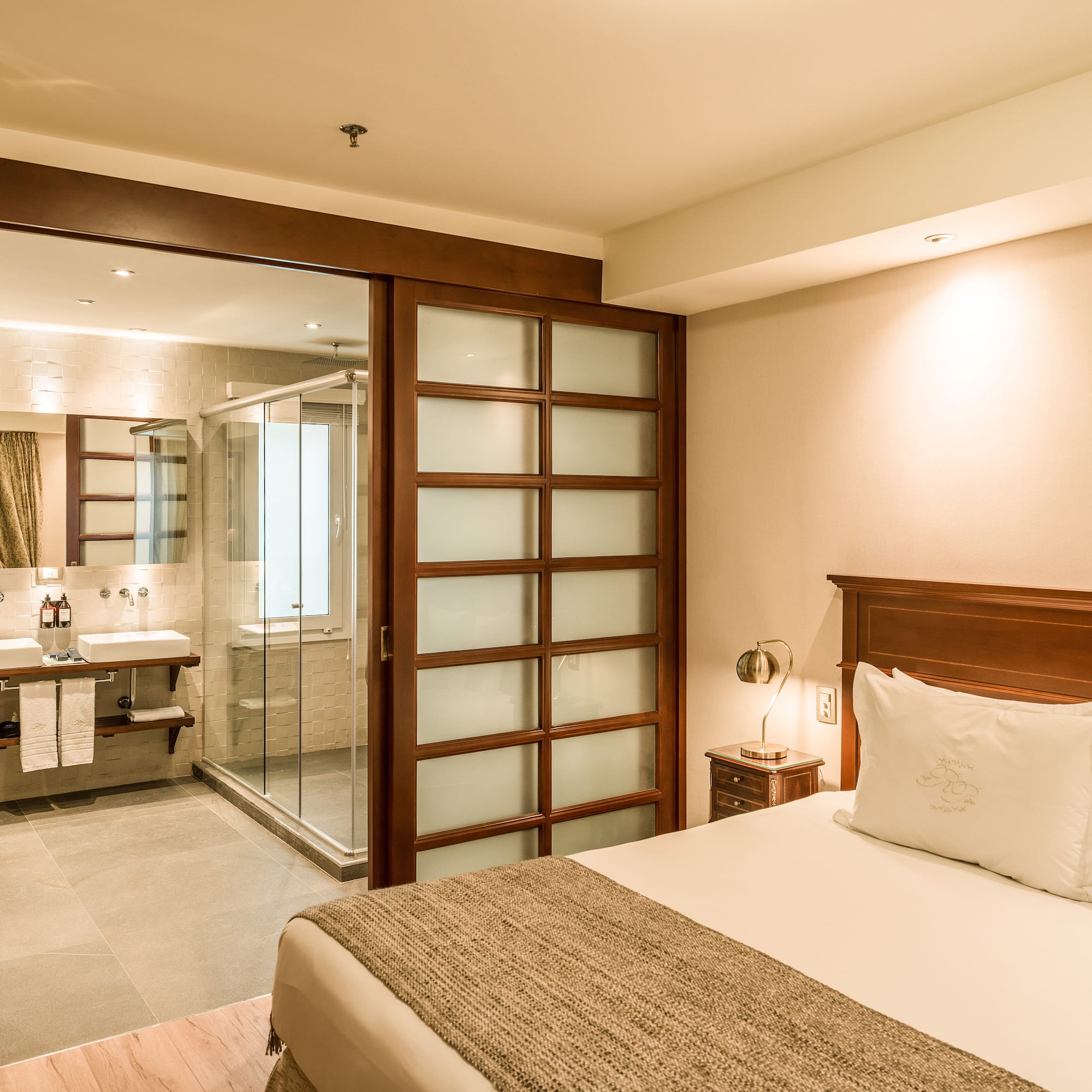 a bedroom with a glass door and a sink