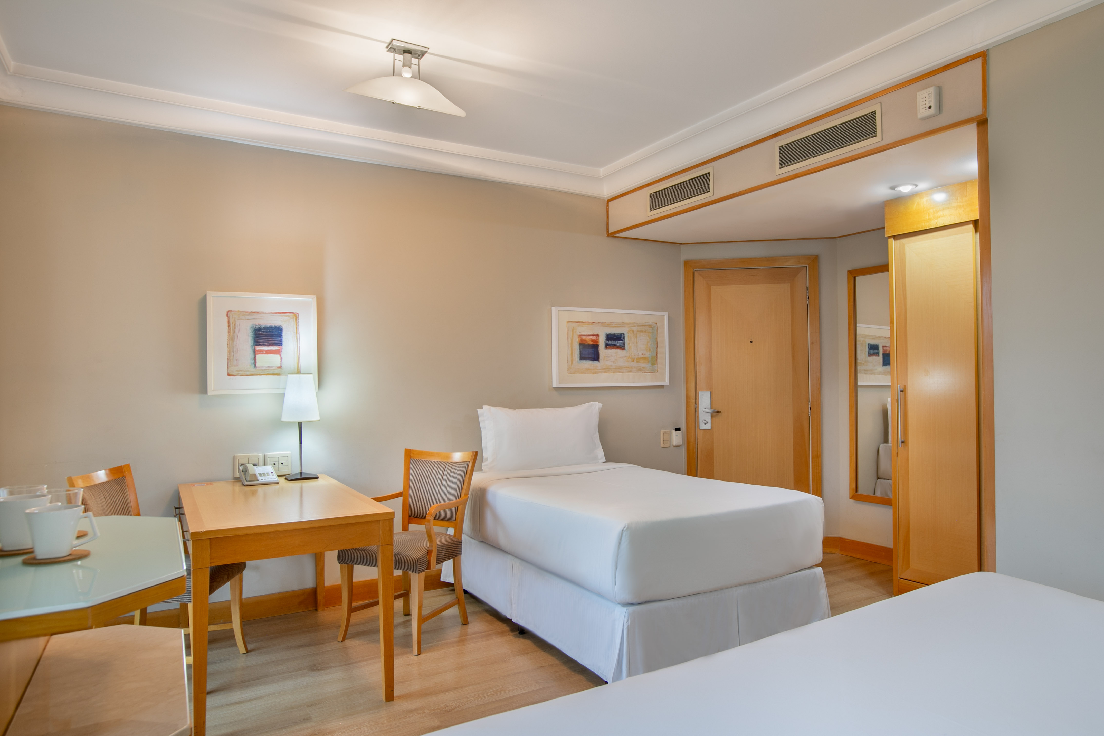 Comfortable hotel room with two twin beds, wooden desk, and modern decor. - The INNSiDE Triple Queen - INNSiDE São Paulo Higienópolis, Sao Paulo