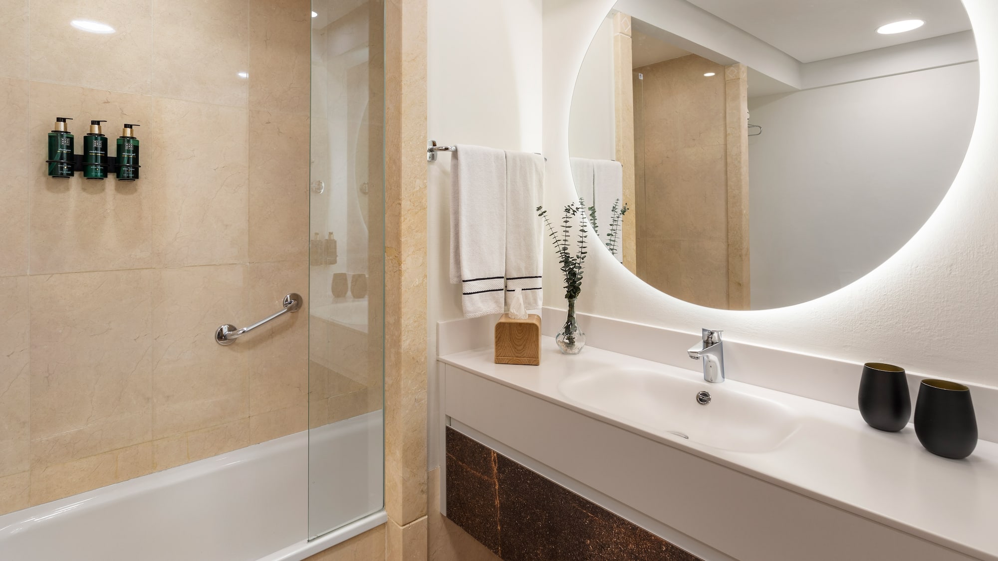 a bathroom with a round mirror and a shower